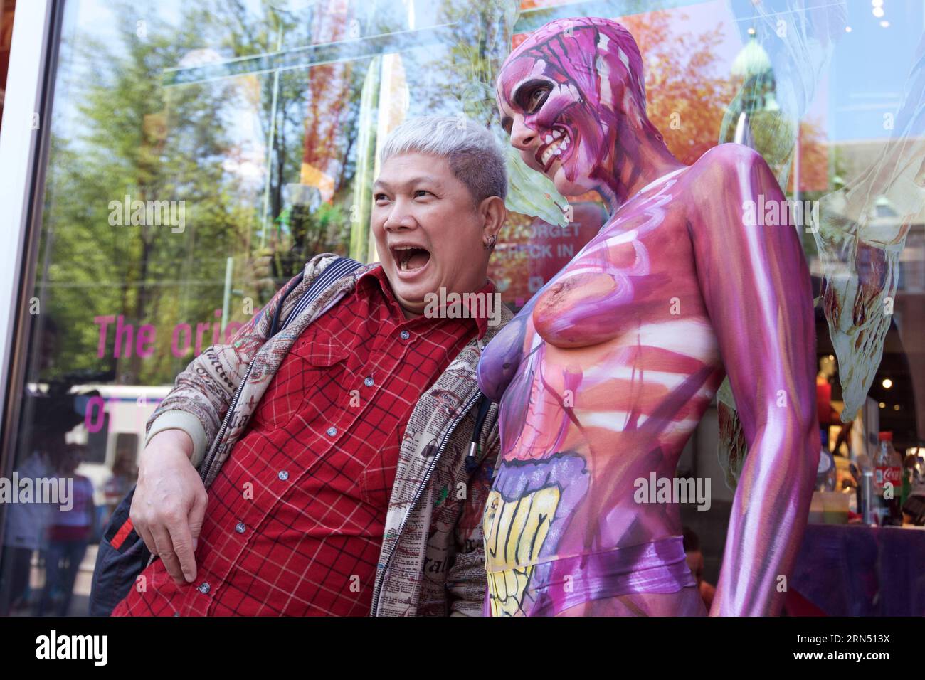 A visitor poses with a body painting model during Under Your Skin , an  exhibition featuring anatomical body paintings, at Dam Square in downtown  Amsterdam, Netherlands, June 7, 2015. ) NETHERLANDS-AMSTERDAM-ART-BODY  PAINTING-EXHIBITION