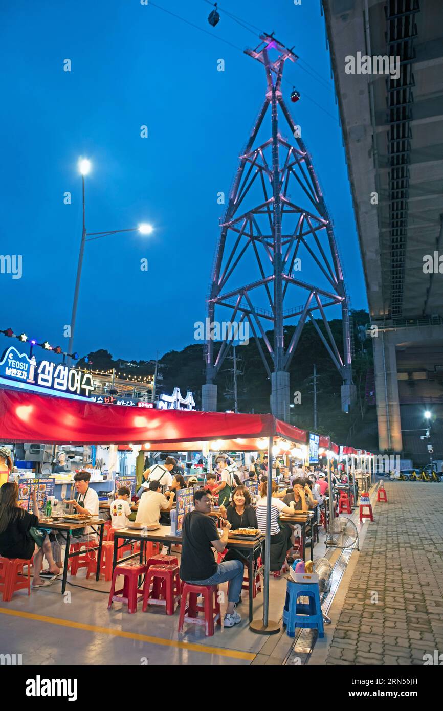 Nangman Pocha night market under Dolsan Bridge, night shot, cable car above, Yeosu, Jeollanam-do Province, South Korea Stock Photo