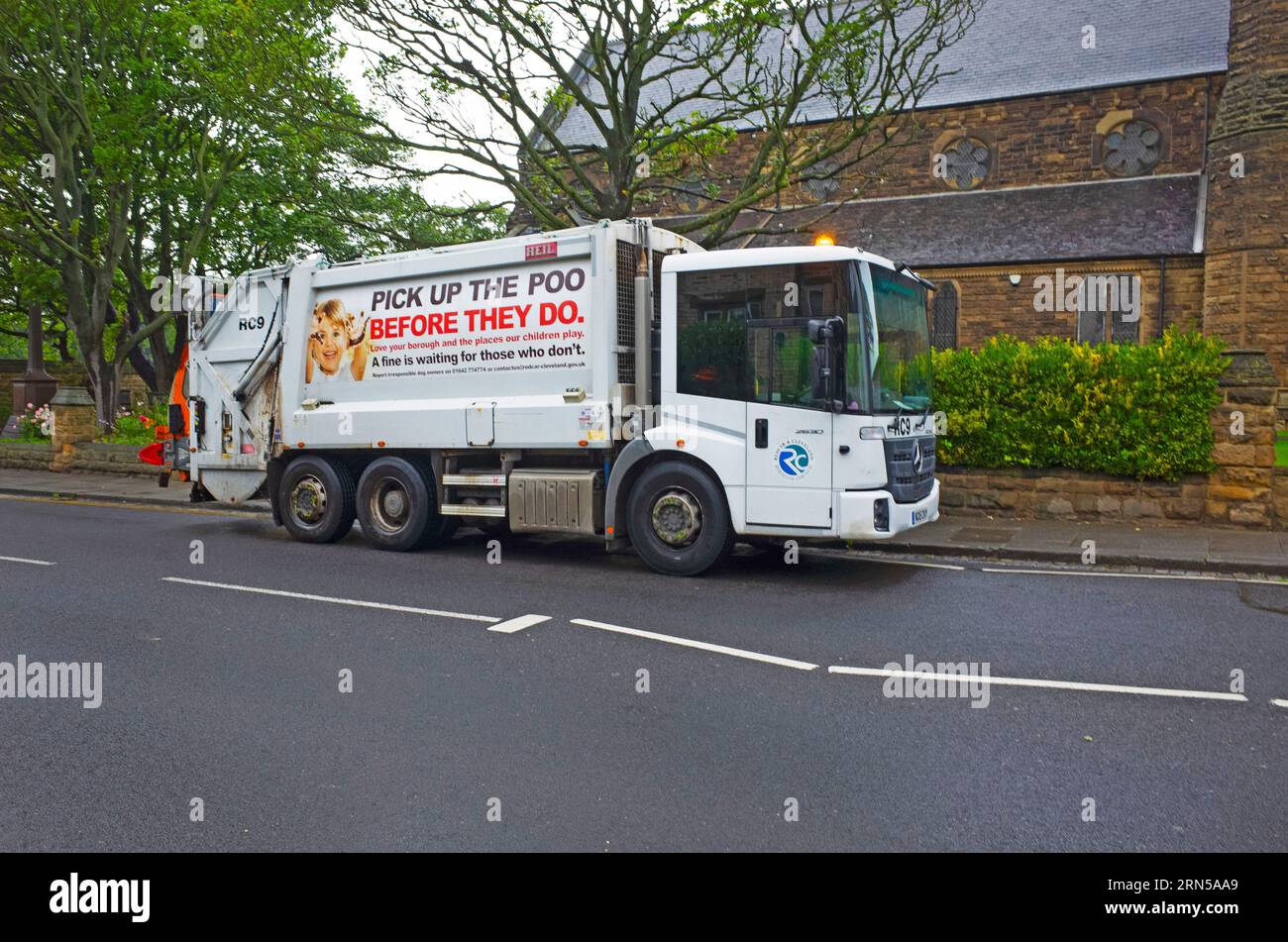 A Recar and Cleveland Council equipped to empty rubbish wheelie bins.  An advertisement on the side of the truck warns against leaving dog faeces Stock Photo