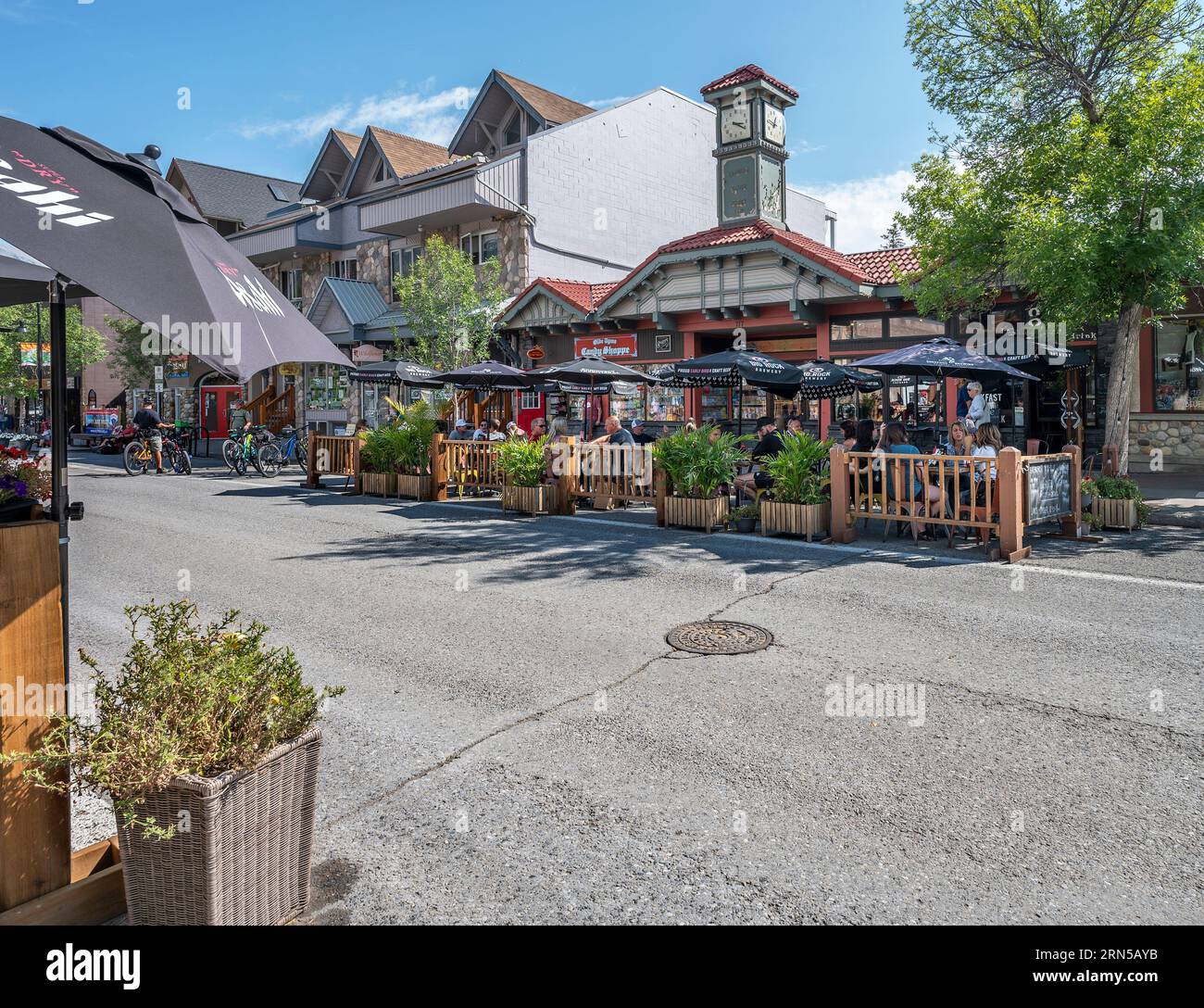 Canmore, Alberta, Canada – August 25, 2023:  People dine outdoors on a closed downtown street Stock Photo