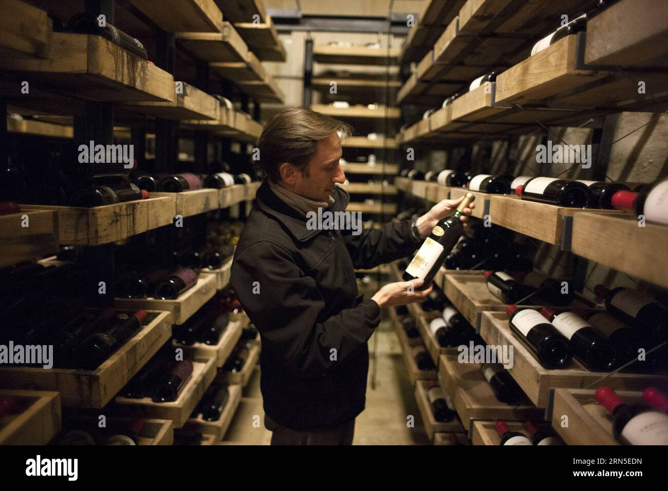 (150623) -- MAIPU, June 23, 2015 -- Image taken on June 22, 2015 shows Gaston Re, sommelier of the wine company Bodegas Trapiche, looking at a bottle of Cabernet Sauvignon 1991 in the cellar of Bodegas Trapiche, in the city of Maipu, Mendoza province, Argentina. Bodegas Trapiche, founded in 1883, is recognized as a pioneer brand in aspects such as the introduction of French vines, the production of varietal wines, the importation of oak barrels from France and the use of stainless steel tanks. According to Valentin Gonzalez, director of the Asian Region of Bodegas Trapiche, the company current Stock Photo