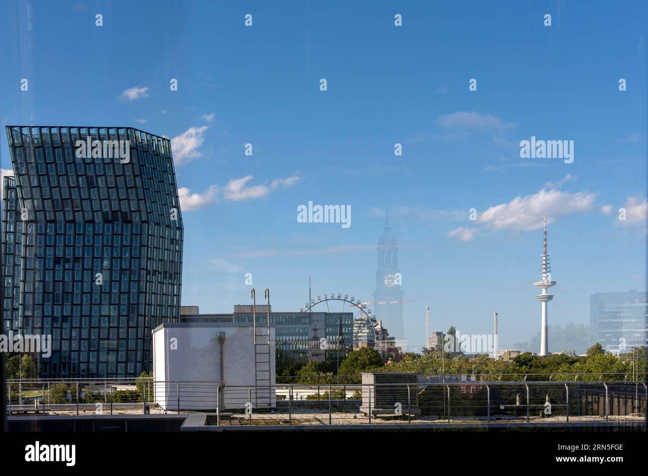 View from a window of the dancing towers, Ferris wheel, television tower, St. Michaelis church as a reflection, Hamburg, Germany Stock Photo