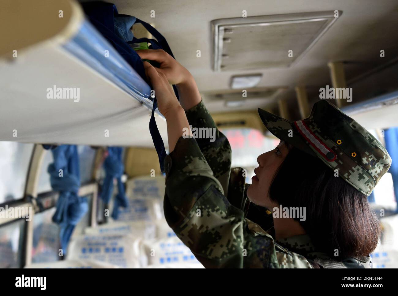 DEHONG, June 24, 2015 -- Zhang Liu checks a bus for contraband at the border checkpoint of Mukang in Dehong Dai-Jingpo Autonomous Prefecture, southwest China s Yunnan Province, June 24, 2015. Born in 1995, Zhang Liu became an anti-drug soldier in border checkpoint of Mukang in 2013. Grown up in an affluent family in central China s Hunan Province, Zhang said that being a soldier had always been her dream, which drove her to join the army after graduating from high school. Being a front line anti-drug force, the border checkpoint of Mukang has captured about 100 kilograms of drugs since the beg Stock Photo
