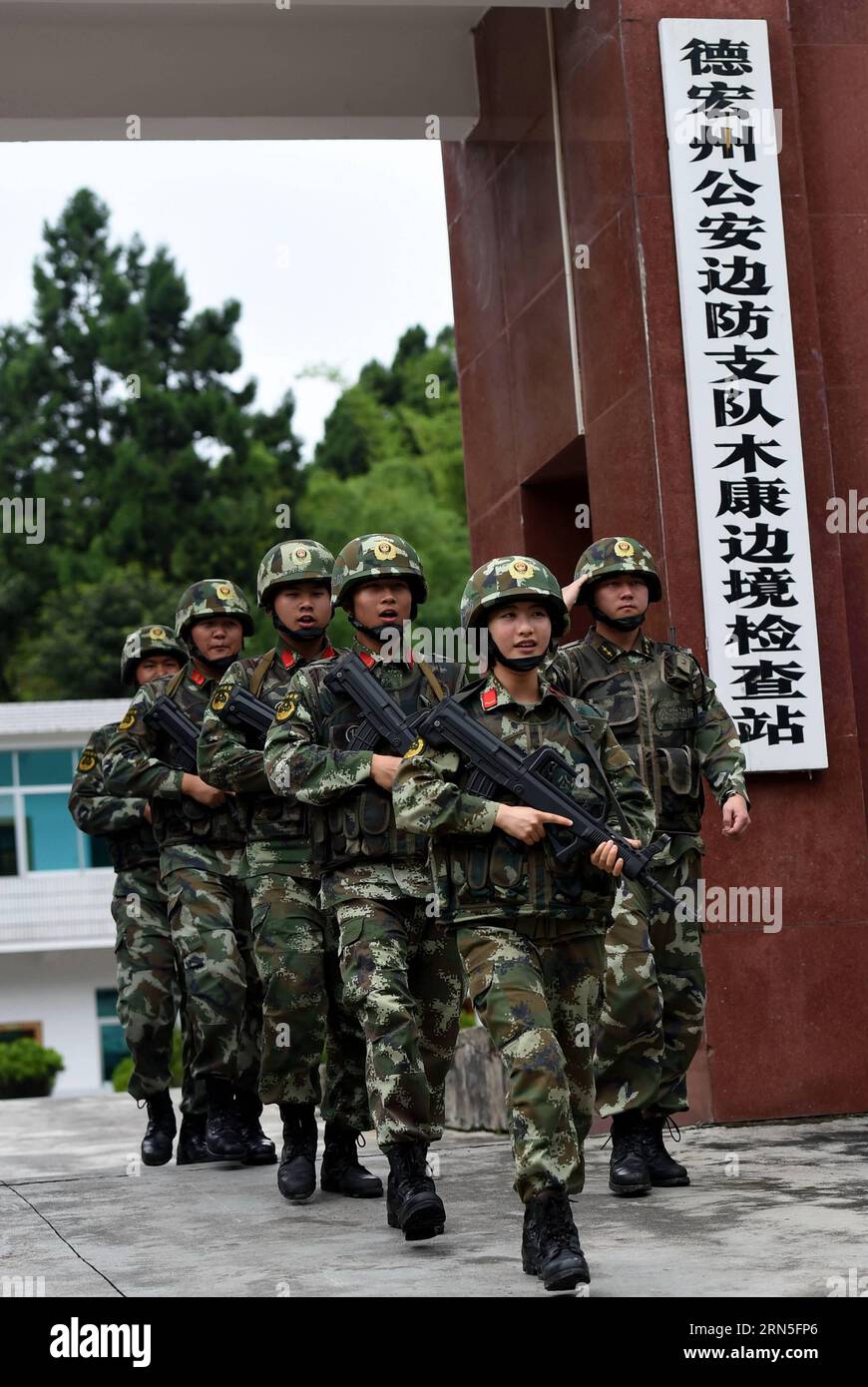 DEHONG, June 24, 2015 -- Zhang Liu (front) and her comrades walk in line at the gate of the border checkpoint of Mukang in Dehong Dai-Jingpo Autonomous Prefecture, southwest China s Yunnan Province, June 24, 2015. Born in 1995, Zhang Liu became an anti-drug soldier in border checkpoint of Mukang in 2013. Grown up in an affluent family in central China s Hunan Province, Zhang said that being a soldier had always been her dream, which drove her to join the army after graduating from high school. Being a front line anti-drug force, the border checkpoint of Mukang has captured about 100 kilograms Stock Photo