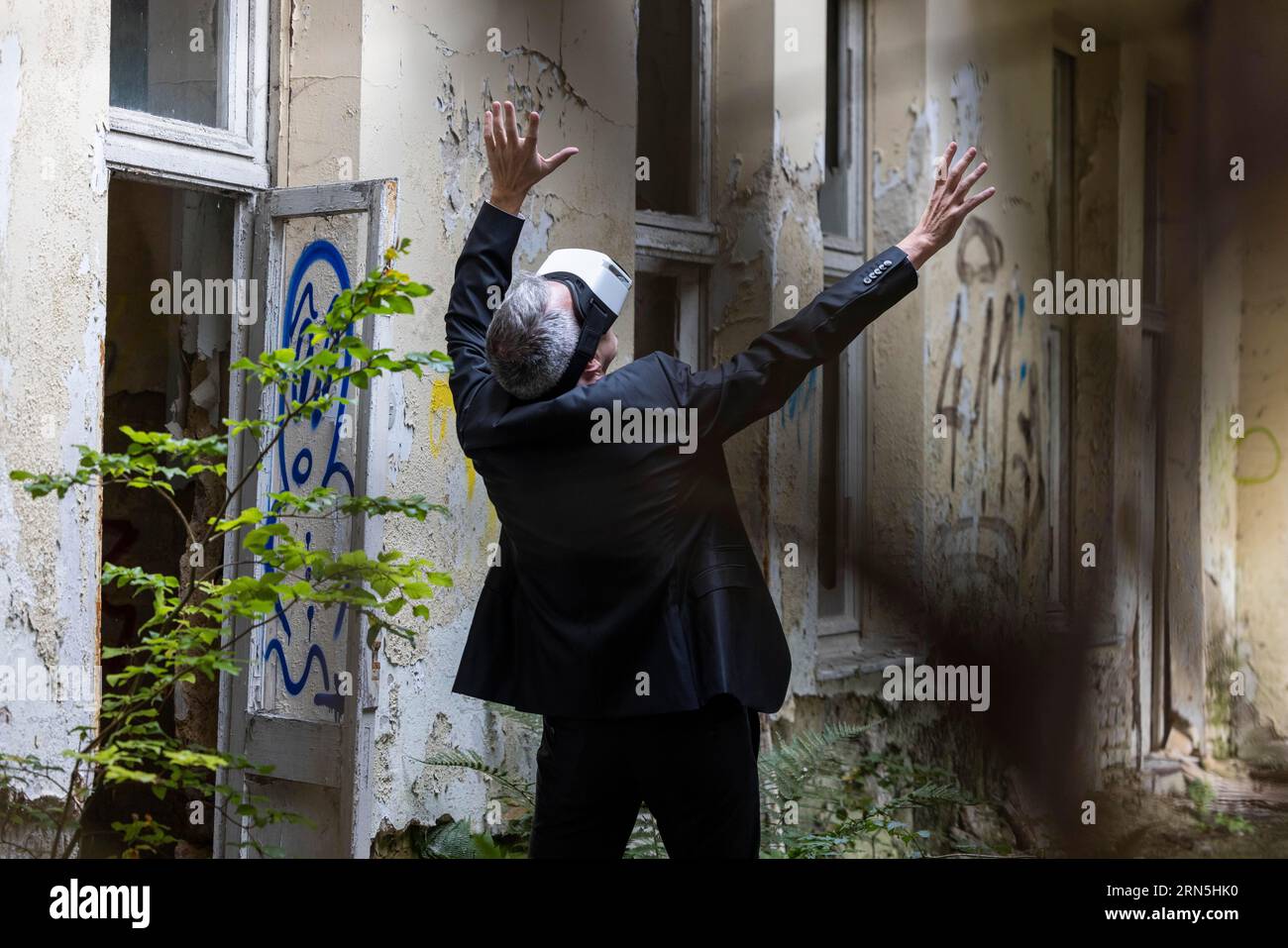Man dressed in suit wearing vr glasses in a dilapidated office building