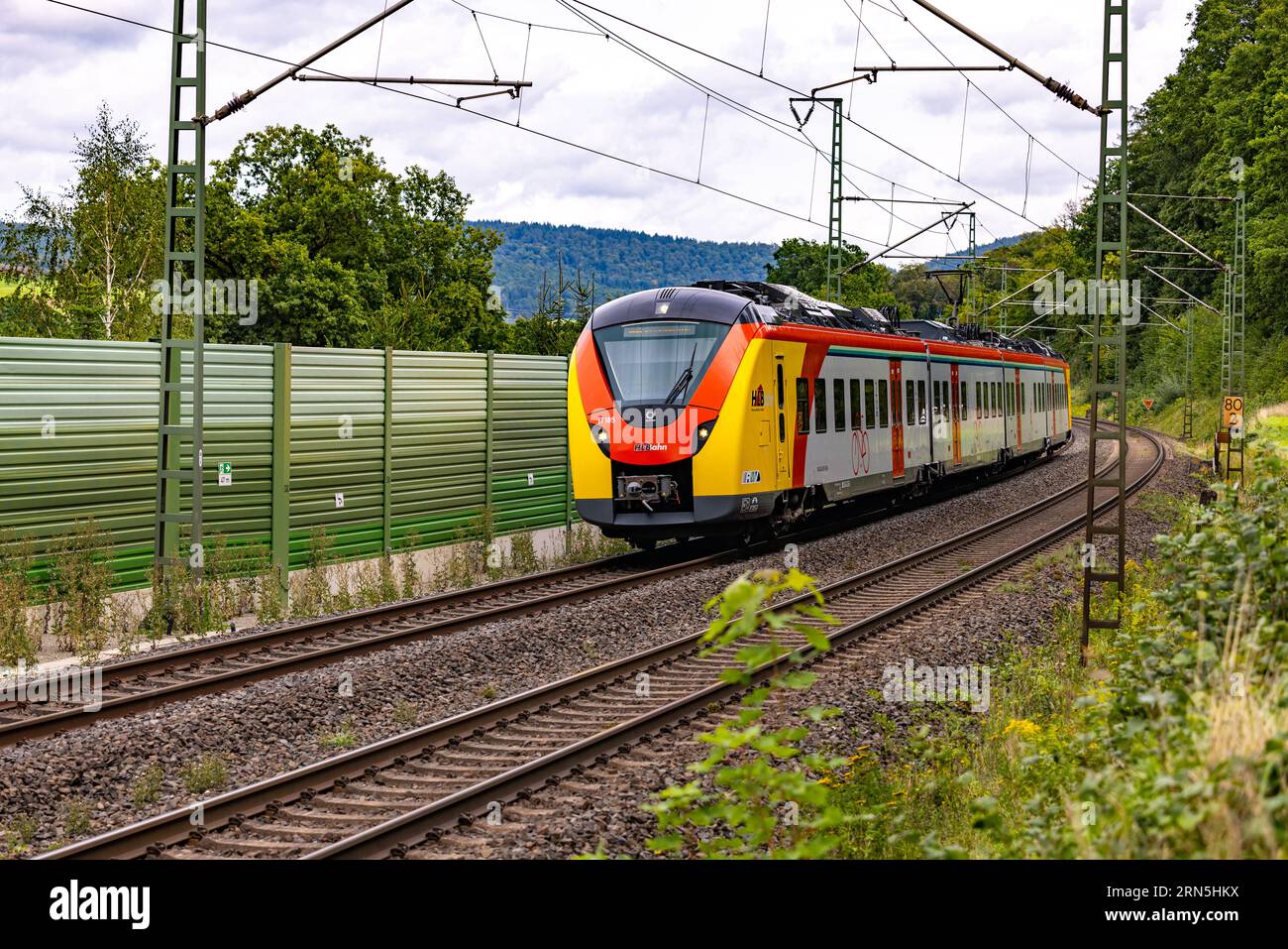A short train of regional railroad passes through rural area for passenger transportation in Bavaria Stock Photo
