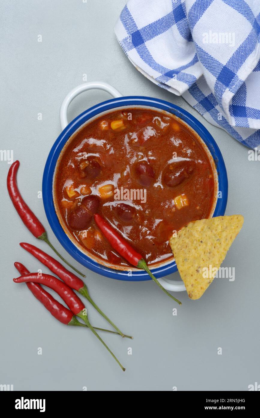 Chilli con carne, bean stew in small pots with taco and chilli peppers Stock Photo