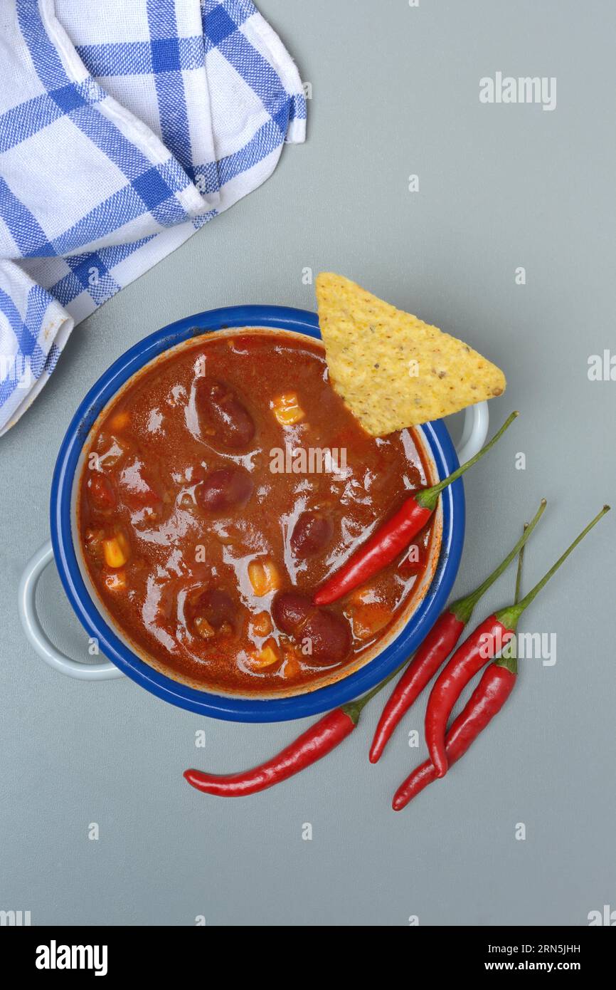 Chilli con carne, bean stew in small pots with taco and chilli peppers Stock Photo