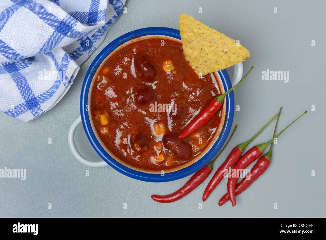 Chilli con carne, bean stew in small pots with taco and chilli peppers Stock Photo