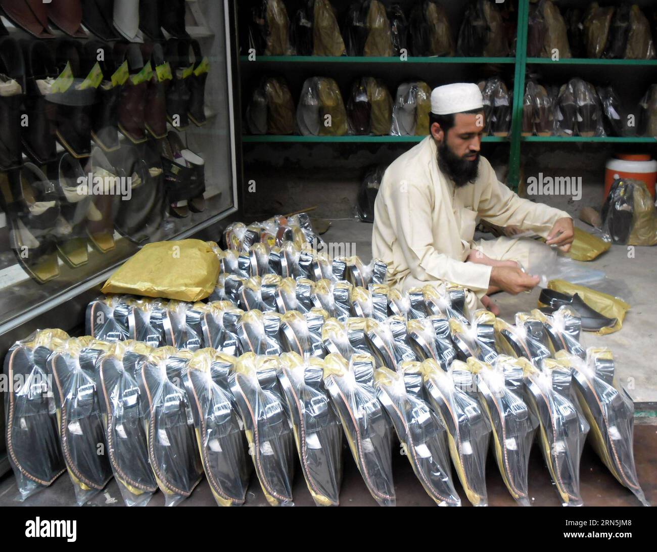 (150627) -- PESHAWAR, June 27, 2015 -- A Pakistani man packs traditional Peshawari Chappal at workshop in northwest Pakistan s Peshawar, June 27, 2015. Peshawari Chappal is a traditional footwear of Pakistan, worn especially by Pashtuns in the Khyber Pakhtunkhwa region of Pakistan. ) PAKISTAN-PESHAWAR-PESHAWARI CHAPPAL AhmadxSidique PUBLICATIONxNOTxINxCHN   150627 Peshawar June 27 2015 a Pakistani Man Packs Traditional  CHAPPAL AT Workshop in Northwest Pakistan S Peshawar June 27 2015  CHAPPAL IS a Traditional Footwear of Pakistan worn especially by  in The Khyber Pakhtunkhwa Region of Pakista Stock Photo