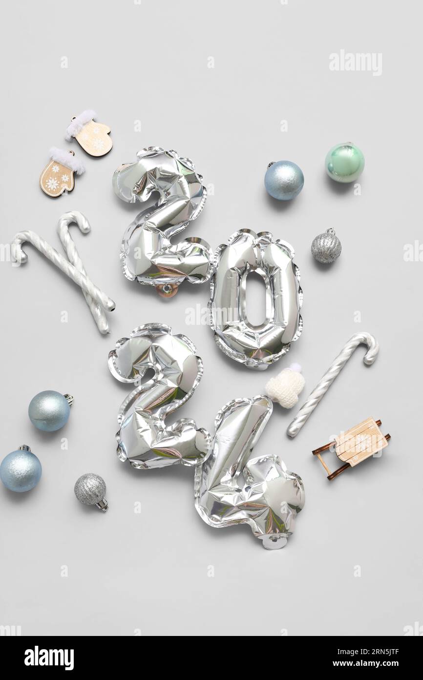 Figure 2024 made of balloons with Christmas decorations on grey