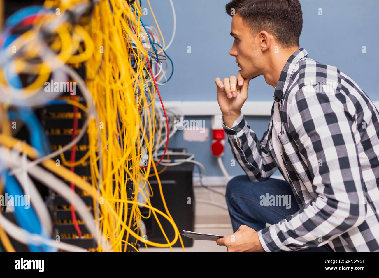 Young network engineer looking wires Stock Photo