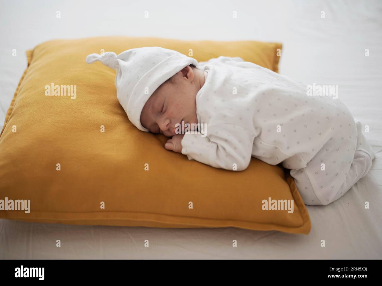 Cute baby sleeping yellow pillow Stock Photo