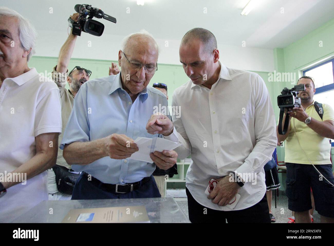 (150705) -- ATHENS, July 5, 2015 -- Greek Finance Minister Yanis Varoufakis (R front) cast his ballot at a polling station in Athens, Greece, July 5, 2015. Greek voters started casting their ballots Sunday in a landmark referendum on a deal with the country s lenders, which may determine whether Greece will avoid a default and possible exit from the eurozone. ) GREECE-ATHENS-REFERENDUM MariosxLolos PUBLICATIONxNOTxINxCHN   150705 Athens July 5 2015 Greek Finance Ministers YANIS Varoufakis r Front Cast His Ballot AT a Polling Station in Athens Greece July 5 2015 Greek Voters started Casting the Stock Photo