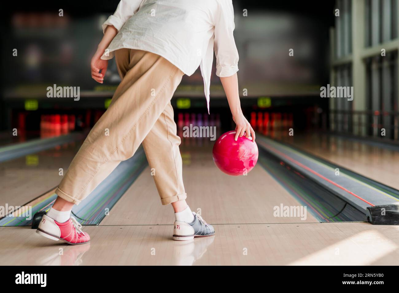 Person throwing red bowling ball Stock Photo