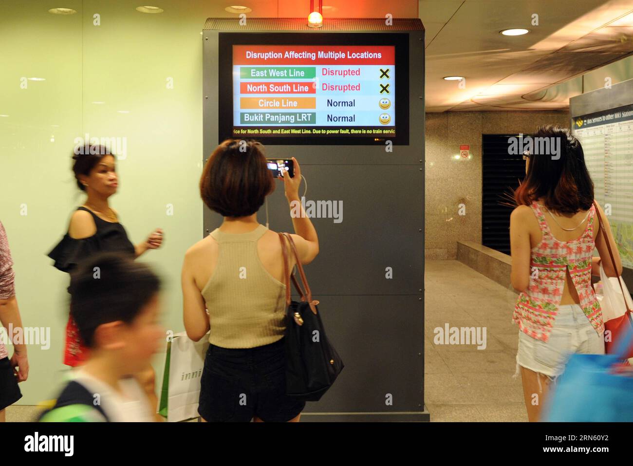 (150707) -- SINGAPORE, July 7, 2015 -- People read the information on MRT disruption on a notice board at Singapore s Dhoby Ghaut MRT Station on July 7, 2015. Train services on Singapore s North-South and East-West MRT Lines were disrupted at evening peak hours due to electrical malfunction on Tuesday, the second time after the East-West MRT Line malfunction in March. ) SINGAPORE-MRT-ELECTRICAL MALFUNCTION ThenxChihxWey PUBLICATIONxNOTxINxCHN   150707 Singapore July 7 2015 Celebrities Read The Information ON MRI disruption ON a Notice Board AT Singapore S  Ghaut MRI Station ON July 7 2015 Trai Stock Photo