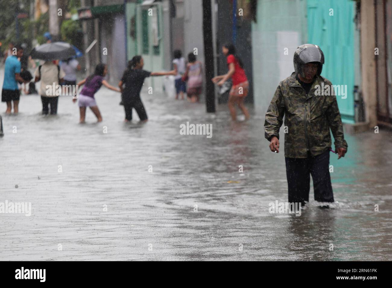 (150708) -- MALABON CITY, July 8, 2015 -- Residents wade through a flooded street in Malabon City, the Philippines, July 8, 2015. Typhoon Chan-hom (local name Falcon) with maximum sustained winds of 130 kph near the center and gustiness of up to 160 kph brought heavy rain, strong winds, lightning and floods in northern Philippines, causing school and office suspensions, and cancellations in air and sea travel. ) (lrz) PHILIPPINES-MALABON CITY-FLOOD RouellexUmali PUBLICATIONxNOTxINxCHN   150708 Malabon City July 8 2015 Residents Calf Through a flooded Street in Malabon City The Philippines July Stock Photo