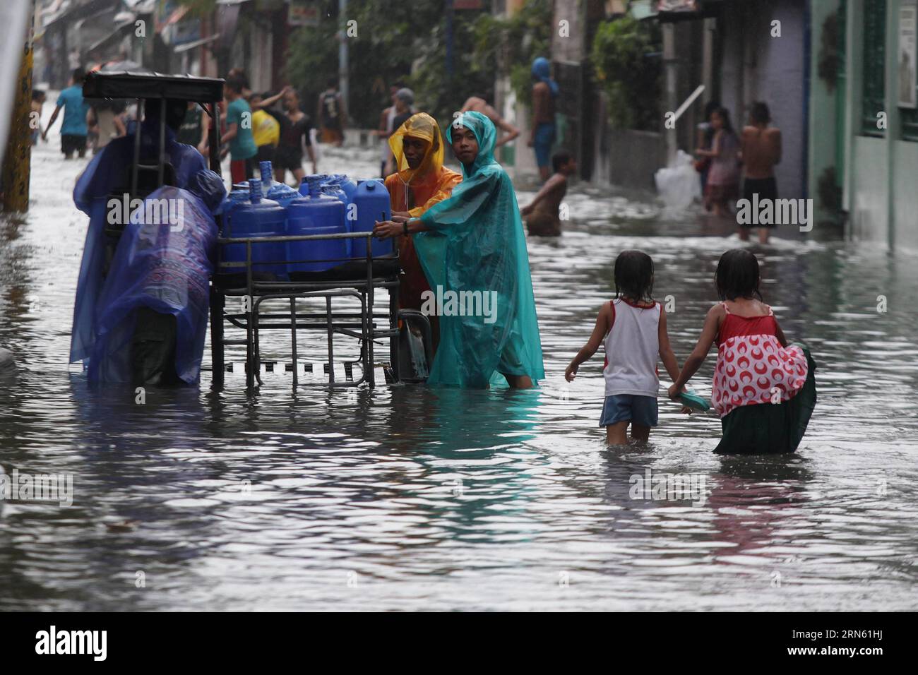 (150708) -- MALABON CITY, July 8, 2015 -- Residents wade through a flooded street in Malabon City, the Philippines, July 8, 2015. Typhoon Chan-hom (local name Falcon) with maximum sustained winds of 130 kph near the center and gustiness of up to 160 kph brought heavy rain, strong winds, lightning and floods in northern Philippines, causing school and office suspensions, and cancellations in air and sea travel. ) (lrz) PHILIPPINES-MALABON CITY-FLOOD RouellexUmali PUBLICATIONxNOTxINxCHN   150708 Malabon City July 8 2015 Residents Calf Through a flooded Street in Malabon City The Philippines July Stock Photo