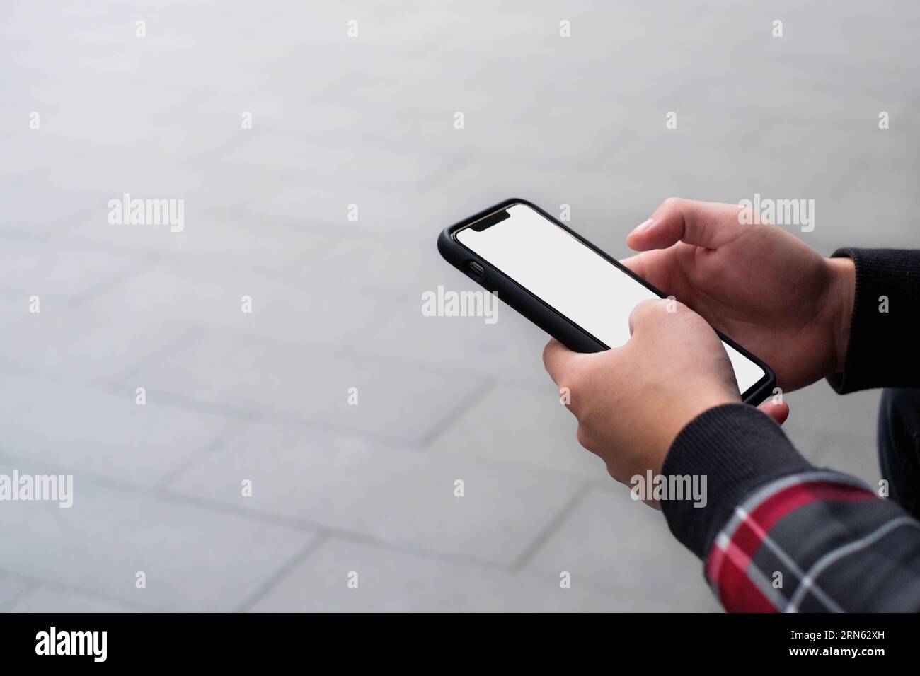 Holding mobile phone with copy space background Stock Photo