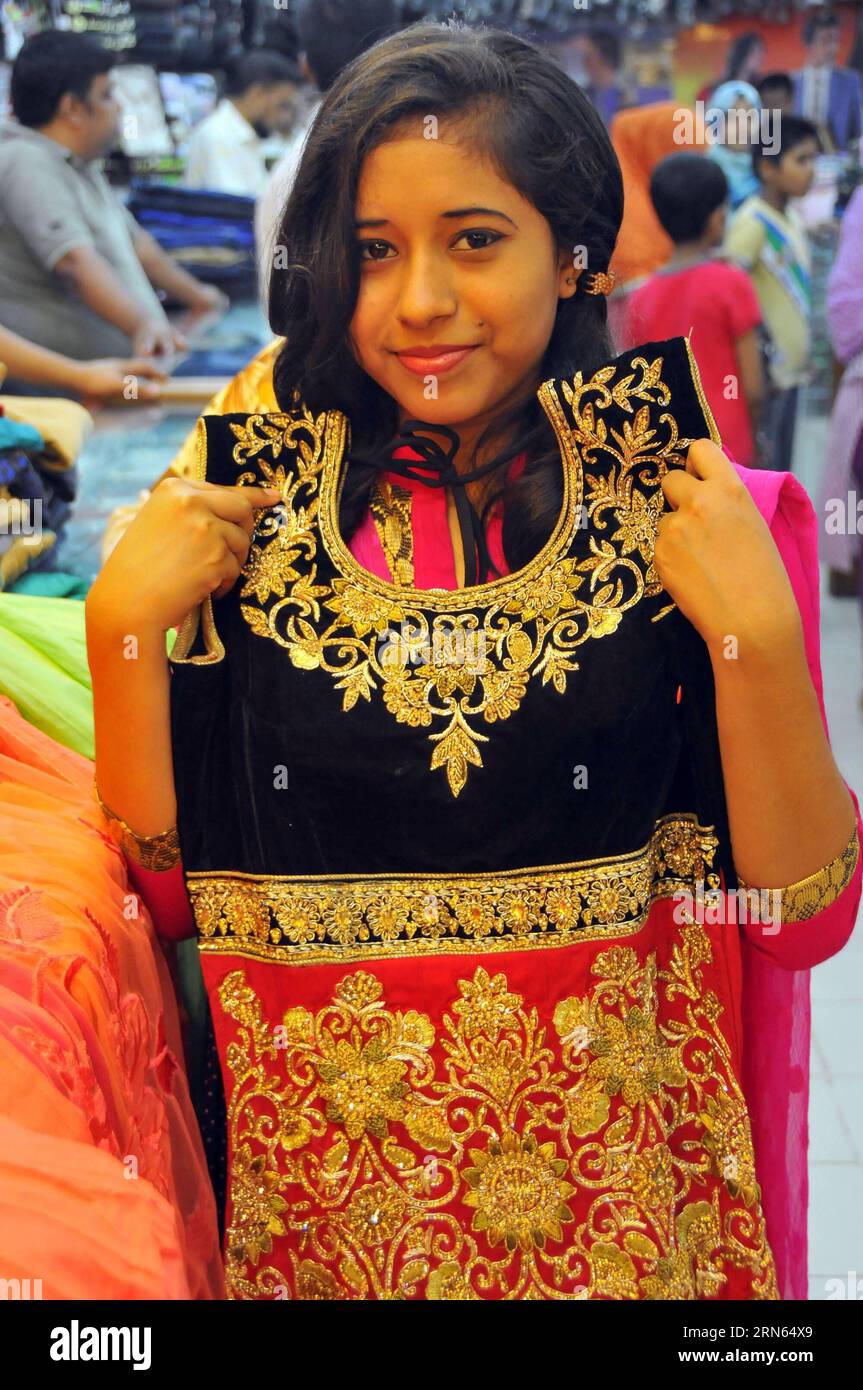 (150711) DHAKA, July 11, 2015 A woman chooses a dress at a