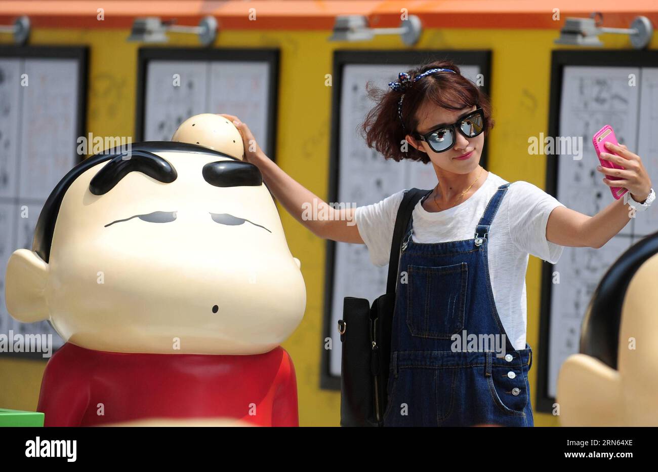 (150711) -- SHENYANG, July 11, 2015 -- A citizen takes a selfie with a figure of Crayon Shin-chan when visiting the exhibition marking the 25th anniversary of Japanese manga series Crayon Shin-chan in Shenyang, northeast China s Liaoning Province July 11, 2015. Dozens of manga and theatrical version of Crayon Shin-chan and related figures were displayed on the exhibition that opened to public on Saturday. (mcg) CHINA-SHENYANG-CRAYON SHIN-CHAN-25TH ANNIVERSARY(CN) ZhangxWenkui PUBLICATIONxNOTxINxCHN   150 711 Shenyang July 11 2015 a Citizen Takes a Selfie With a Figure of crayon Shin Chan When Stock Photo