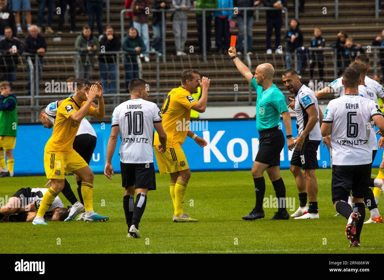 Referee Nicolas Winter shows the red card to player Luca KERBER left (1.FC Saarbruecken), Julian GUeNTHER-SCHMIDT (1.FC Saarbruecken) protests in Stock Photo