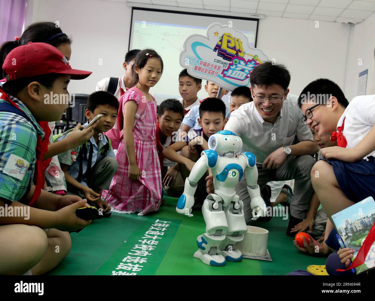 (150716) -- SHANGHAI, July 16, 2015 -- Professor Leng Chuntao introduces Robot Nao to children interested in scientific invention at a robot laboratory in Shanghai Jiaotong University, east China, July 16, 2015. Nao is a 58-centimeter tall robot developed and manufactured by Aldebaran Robotics, a Paris-based company. ) (dhf) CHINA-SHANGHAI-CHILDREN-MEET-ROBOT (CN) LiuxYing PUBLICATIONxNOTxINxCHN   150716 Shanghai July 16 2015 Professor Ling Chuntao introduces Robot Nao to Children interested in Scientific Invention AT a Robot Laboratory in Shanghai Jiaotong University East China July 16 2015 N Stock Photo