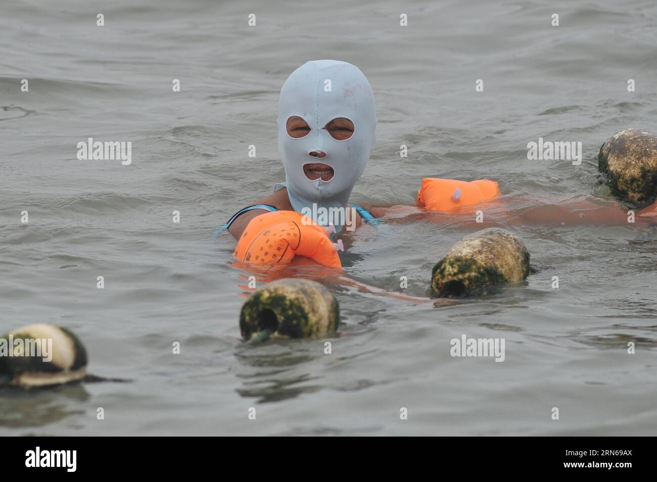 (150716) QINGDAO, July 16, 2015 A woman wearing Facekini swims in