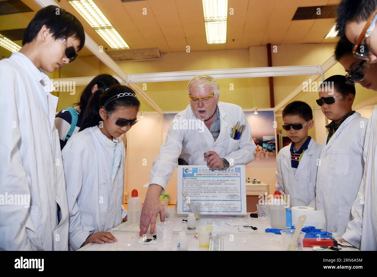 (150717) -- BEIJING, July 17, 2015 -- A scientist from the Beijing office of Britain s Royal Society of Chemistry helps children to do experiments at the 2015 China Science Festival in Beijing, China, July 17, 2015. The 2015 China Science Festival kicked off in Beijing Exhibition Center on Friday, attracting 125 organizations, institutes and enterprises from 12 countries and regions. The theme of the festival is light and color. ) (zhs) CHINA-BEIJING-SCIENCE FESTIVAL (CN) ChenxYehua PUBLICATIONxNOTxINxCHN   150717 Beijing July 17 2015 a Scientist from The Beijing Office of Britain S Royal Soci Stock Photo