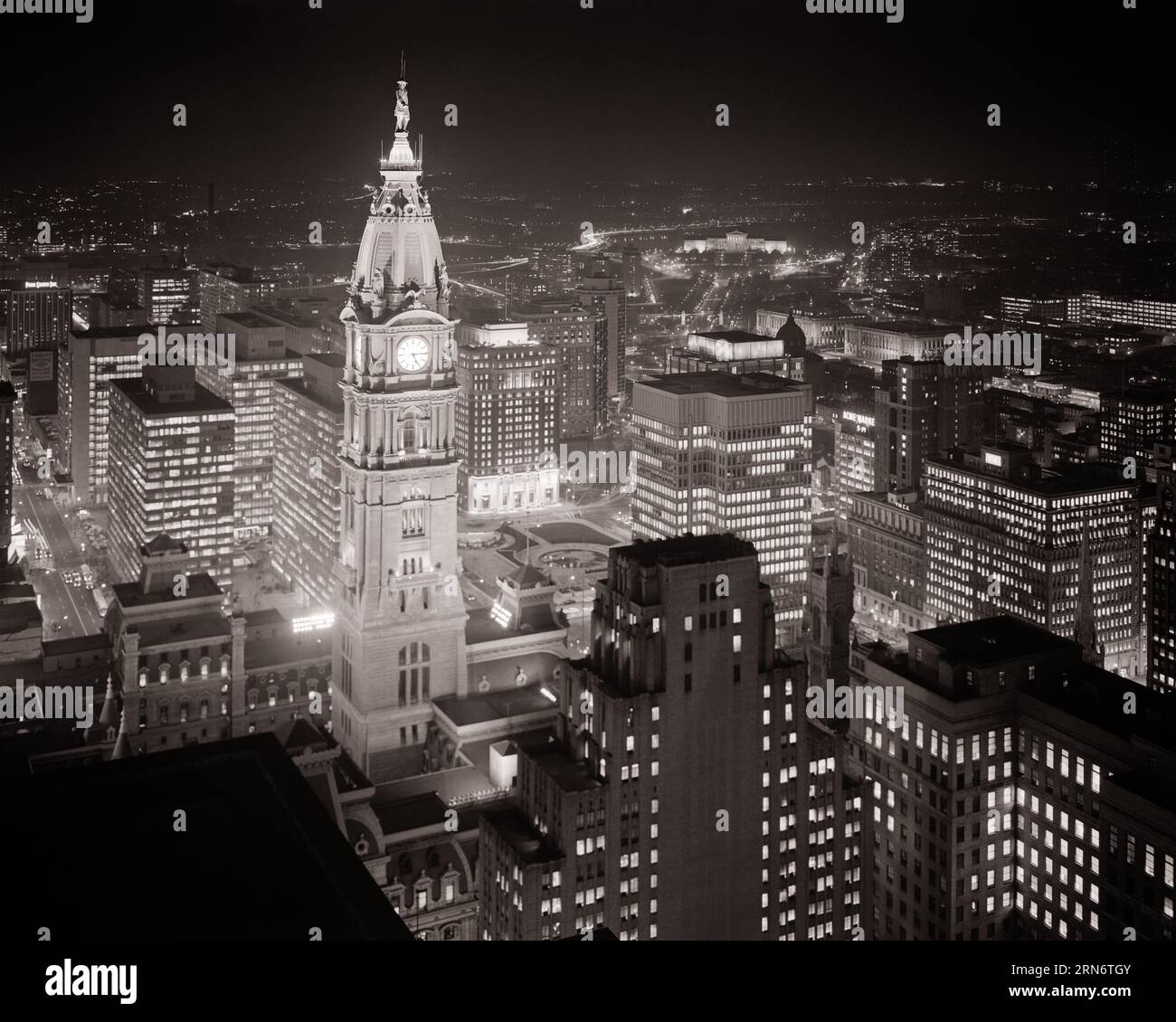 1960s NIGHT SKYLINE ILLUMINATED TOWER OF CITY HALL THE WORLD’S LARGEST FREE-STANDING GRANITE STRUCTURE PHILADELPHIA PA USA  - p7418 HAR001 HARS DREAMS STRUCTURE MARBLE CITY HALL HIGH ANGLE ADVENTURE PROPERTY EXCITEMENT EXTERIOR PA POLITICS REAL ESTATE COMMONWEALTH STRUCTURES CITIES KEYSTONE STATE MASONRY MATERIALS PRINCIPAL EDIFICE 1969 ILLUMINATED LIMESTONE NIGHTTIME AERIAL VIEW BLACK AND WHITE CITY OF BROTHERLY LOVE GRANITE HAR001 MASSIVE MAYOR OLD FASHIONED WILLIAM PENN Stock Photo