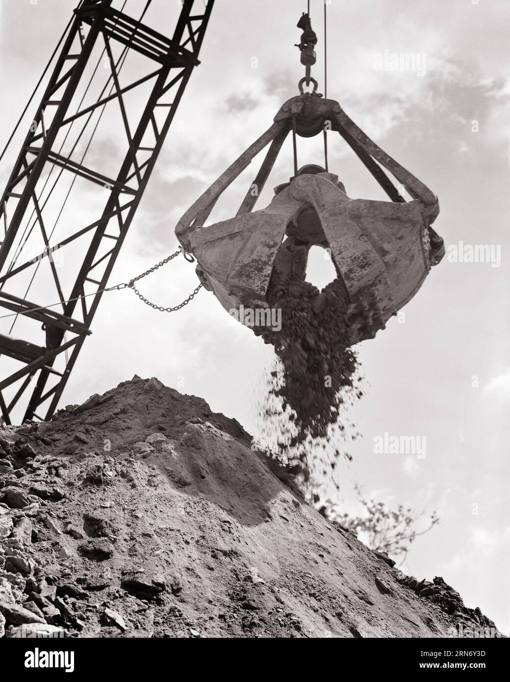 1950s CRANE OPERATING A CLAMSHELL BUCKET DUMPING A LOAD OF EARTH DURING EXCAVATING - i1667 HAR001 HARS OLD FASHIONED Stock Photo