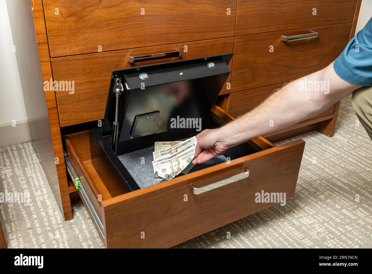 Person placing valuables in hotel room safe Stock Photo Alamy