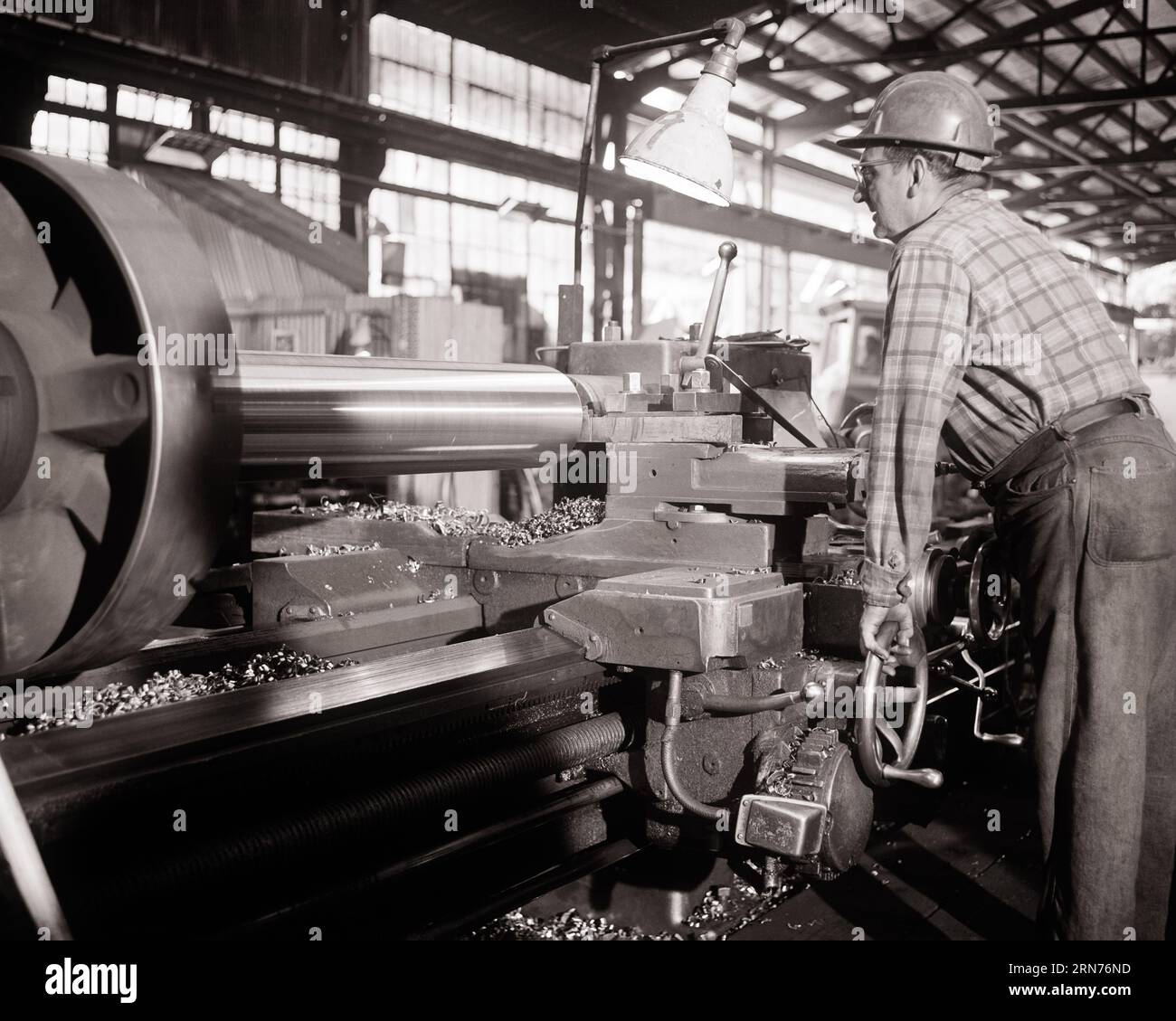 1970s MAN OPERATING A TURNING LATHE IN STEEL FORGING FACTORY - i6161 HAR001 HARS CAUCASIAN ETHNICITY FORGING HAR001 LABORING OLD FASHIONED Stock Photo