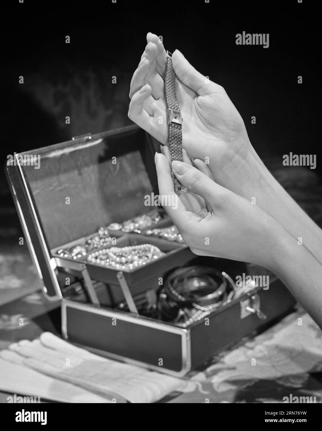 1940s MANICURED FEMALE HANDS HOLDING A WRISTWATCH ABOVE AN OPEN JEWELRY CASE  - s2195 HAR001 HARS MID-ADULT MID-ADULT WOMAN BLACK AND WHITE CAUCASIAN ETHNICITY HANDS ONLY HAR001 OLD FASHIONED REPRESENTATION TIMEPIECE Stock Photo