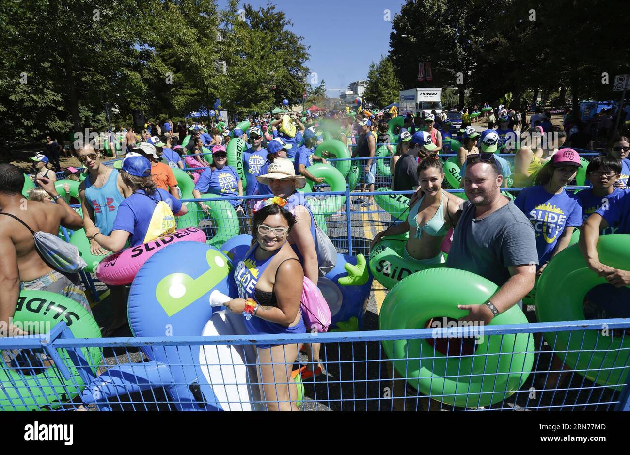 Participants line up for an hour to wait for their turn during the Slide  the city event held at a closed street in North Vancouver, Canada, Aug. 22,  2015. Slide the city