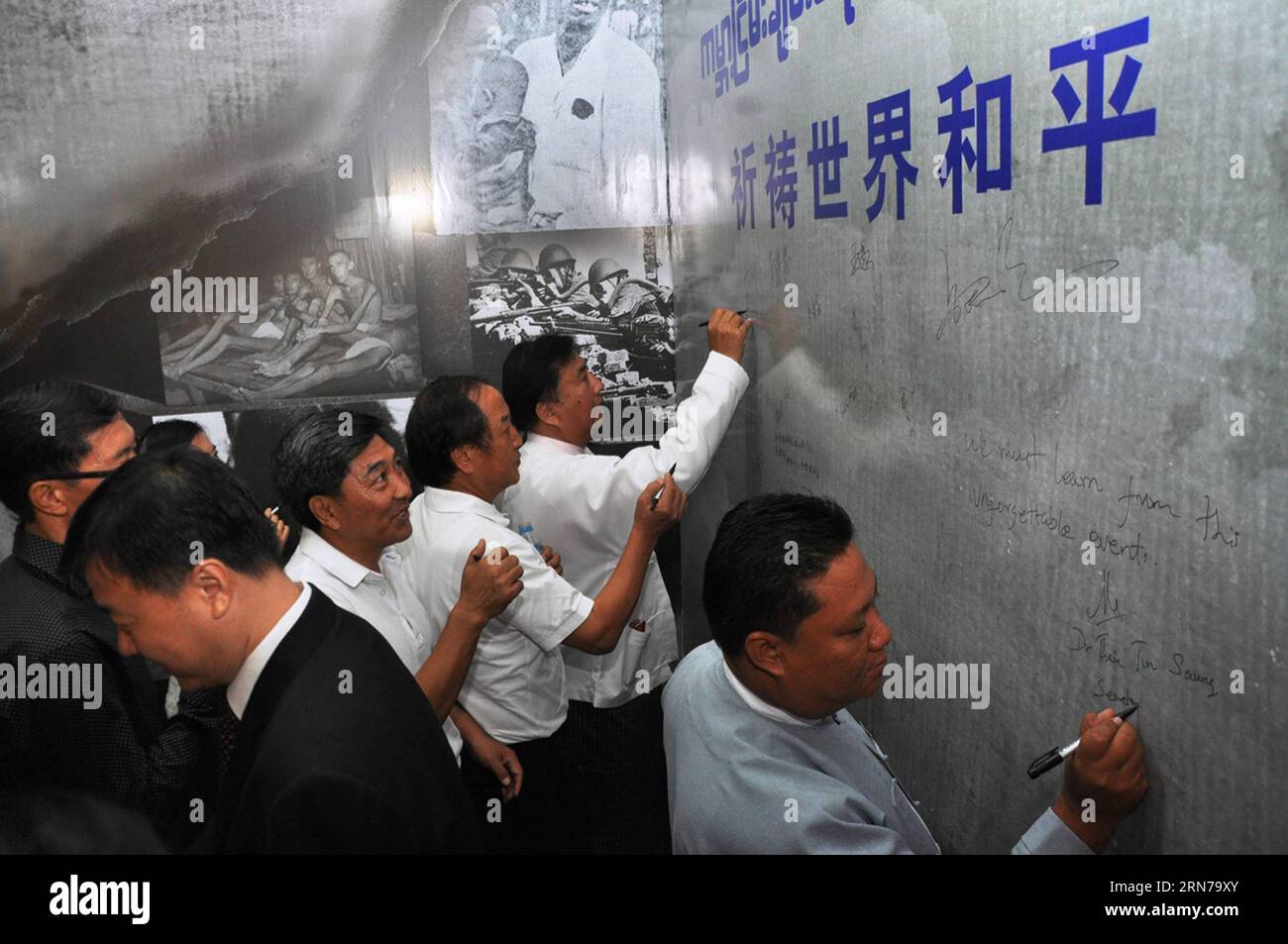 (150829) -- MANDALAY, Aug. 29, 2015 -- Guests sign on a large board for commemoration of the 70th anniversary of the victory of World War II during a photo exhibition in Mandalay, Myanmar, Aug. 29, 2015. A photo exhibition marking the 70th anniversary of the victory of anti-fascist war was launched on Saturday in Mandalay, the second largest city of Myanmar, under the theme of pray for world peace, don t forget the lessons of history. ) (zjy) MYANAMR-MANDALAY-WWII-PHOTO EXHIBITION HouxBaoqiang PUBLICATIONxNOTxINxCHN   150829 Mandalay Aug 29 2015 Guests Sign ON a Large Board for Commemoration o Stock Photo