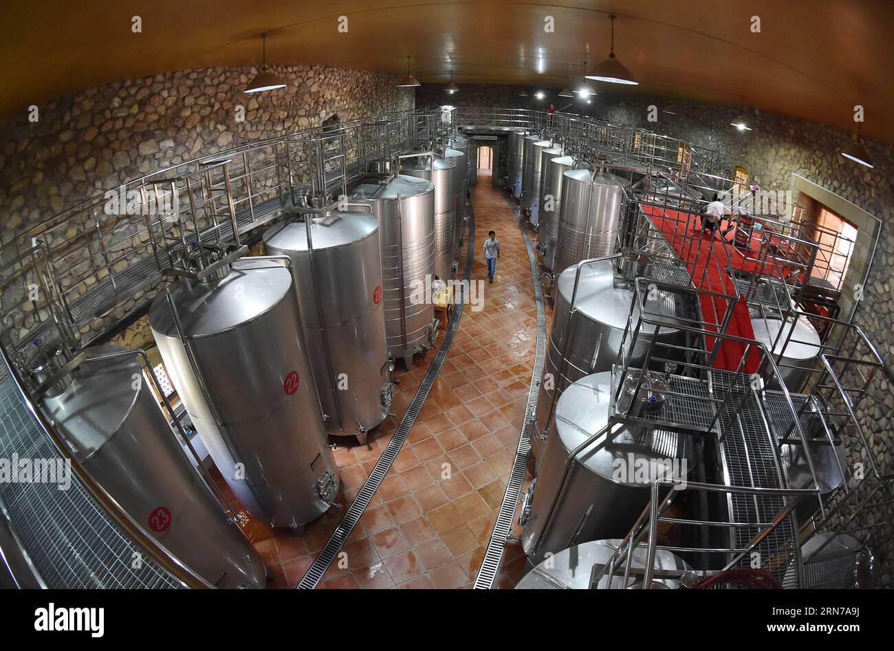 People work at a brewing workshop of Zhihui Yuanshi Chateau at the eastern foot of Helan Mountain, northwest China s Ningxia Hui Autonomous Region, Aug. 28, 2015. Many chateaus at the eastern foot of Helan Mountain, a golden belt for planting grapes, developed their tourism by attracting tourists with chateau cultures. Ningxia region, which has 590,000 mu (39,333 hectares) of vineyards, has planned to build 10 vineyard towns and more than 100 large-scale chateaus by 2020. ) (lfj) CHINA-NINGXIA-CHATEAU TOURISM (CN) LixRan PUBLICATIONxNOTxINxCHN   Celebrities Work AT a Brewing Workshop of Zhihui Stock Photo