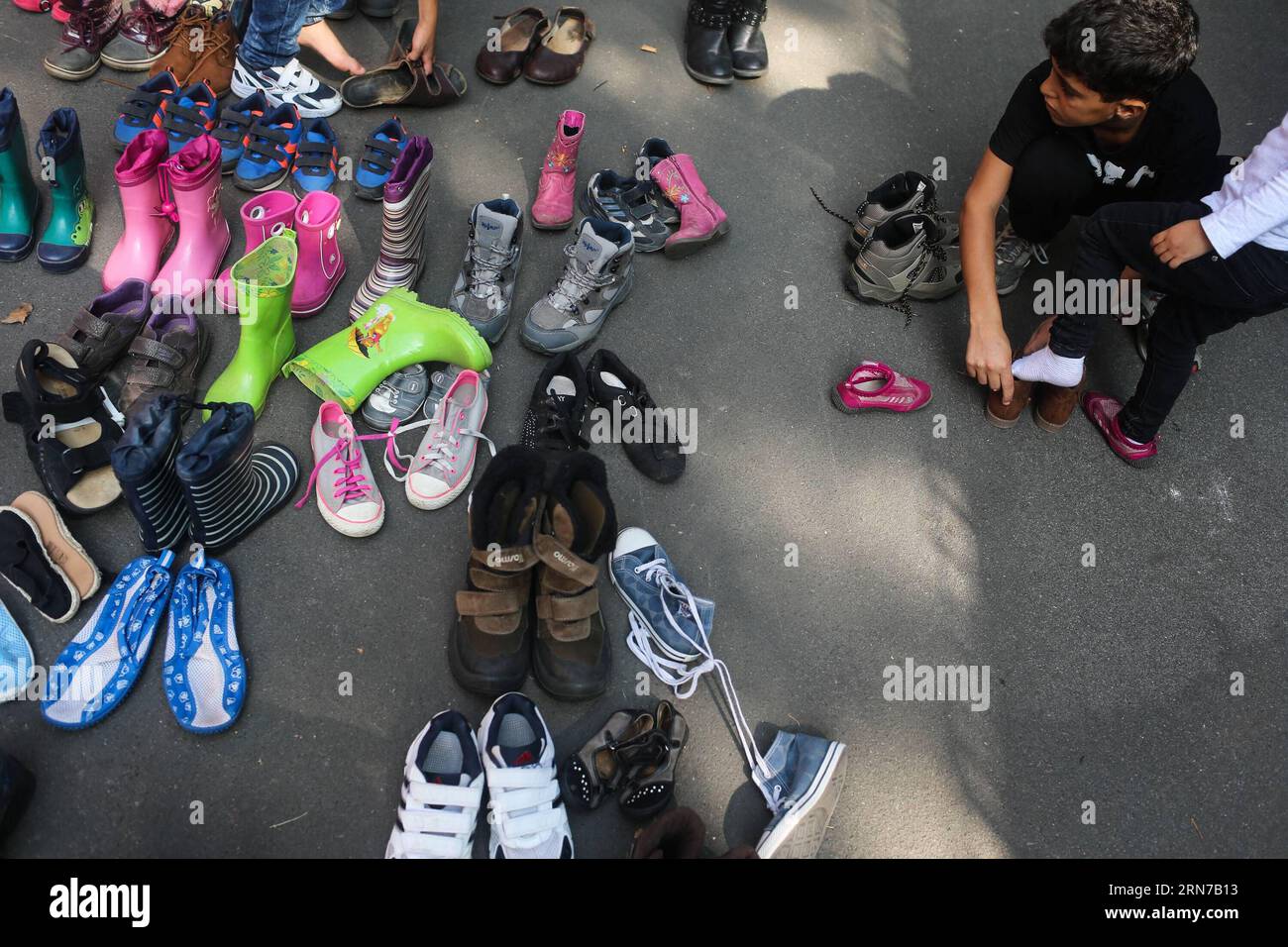 150901) -- BERLIN, Sept. 1, 2015 -- Children try used shoes at the  reception center for refugees and asylum-seekers in Berlin, Germany, on  Sept. 1, 2015. German Chancellor Angela Merkel urged here