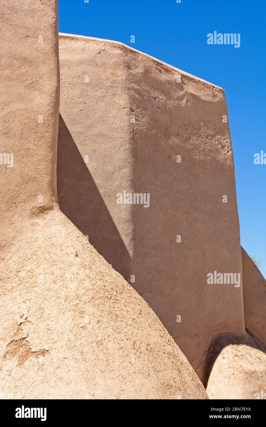 Corner buttress extends from adobe walls of  San Francisco de Asis Catholic mission church  in Taos New Mexico Stock Photo