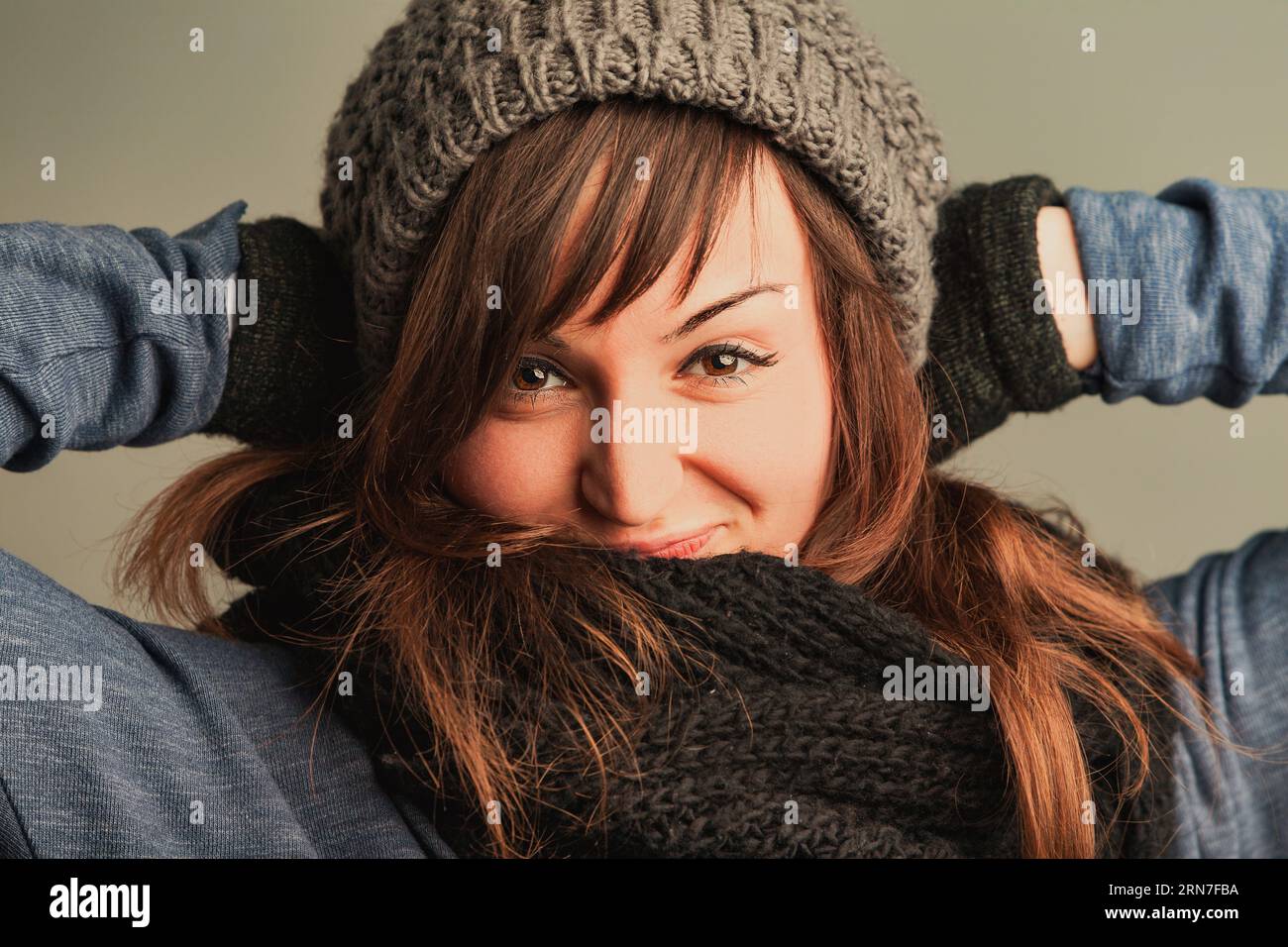 woman with shimmering eyes and flowing brunette hair is comforted and stylish in her winter wear, decked in woolens Stock Photo