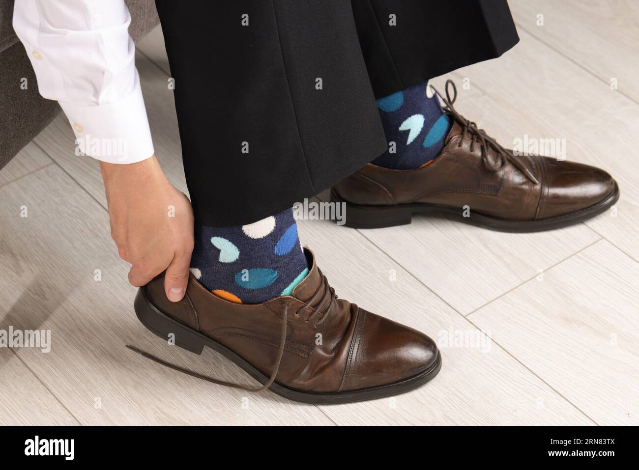 Man with colorful socks putting on stylish shoes indoors, closeup Stock  Photo - Alamy