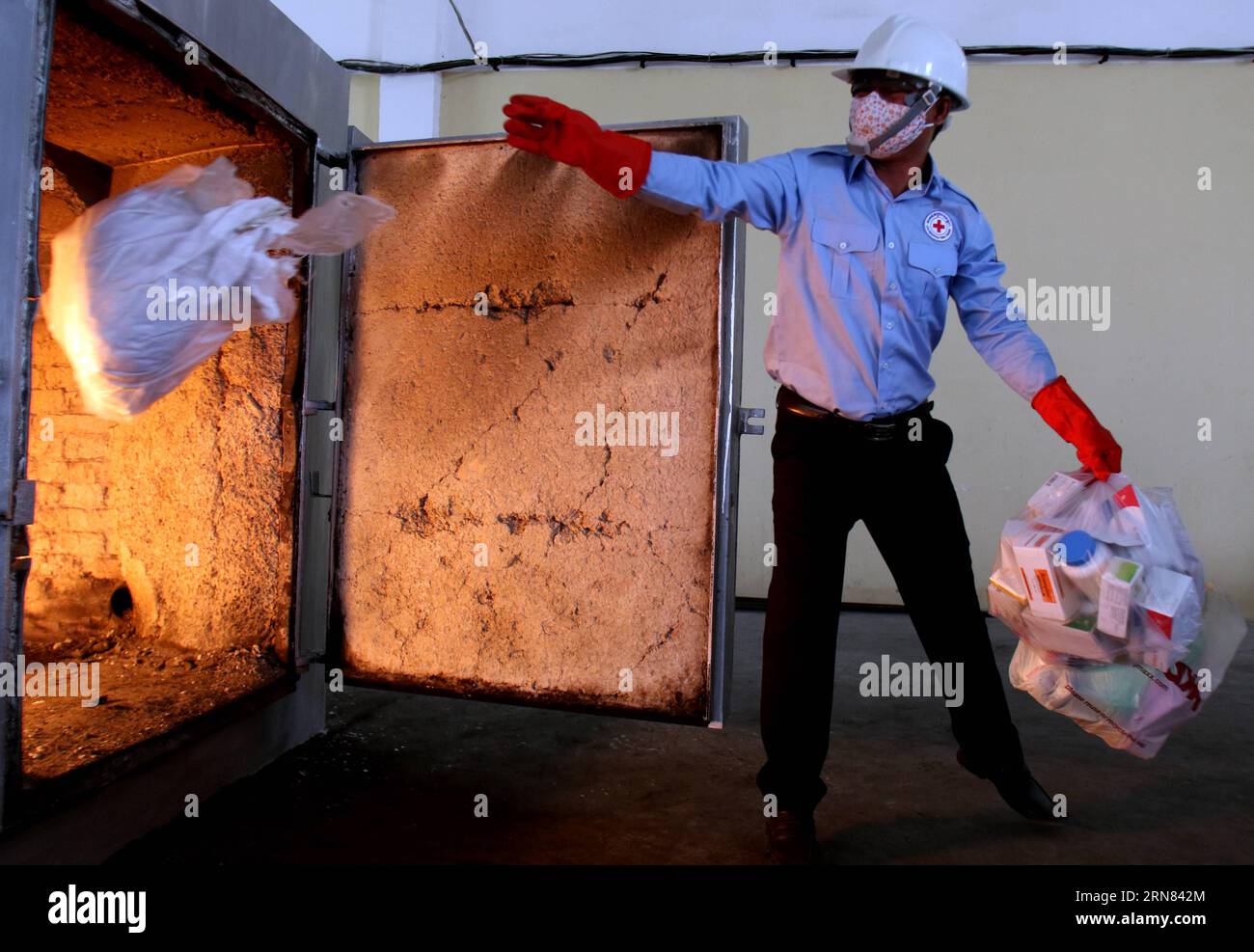 (151005) -- PHNOM PENH, Oct. 5, 2015 -- A Cambodian Red Cross worker throws bags of counterfeit medicines into a garbage incinerator in Phnom Penh, Cambodia, Oct. 5, 2015. Some 1,967 kg of fake medicines were burned down on Monday at a dumpsite on the southwestern outskirts of capital Phnom Penh, officials said. ) CAMBODIA-PHNOM PENH-COUNTERFEIT MEDICINE-BURNED Sovannara PUBLICATIONxNOTxINxCHN   Phnom Penh OCT 5 2015 a Cambodian Red Cross Worker throws Bags of counterfeit Medicines into a Garbage incinerator in Phnom Penh Cambodia OCT 5 2015 Some 1 967 KG of Fake Medicines Were burned Down ON Stock Photo