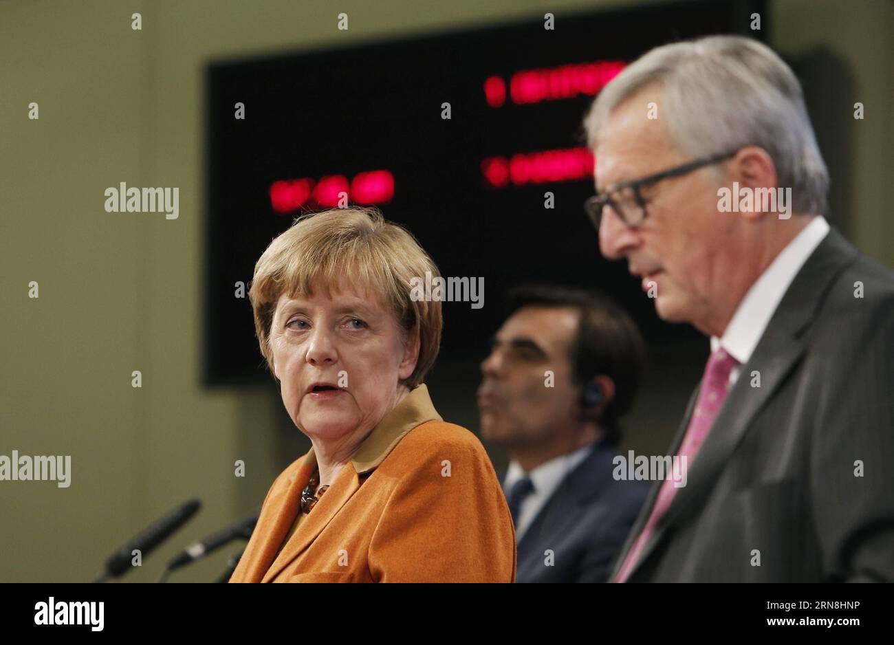 German Chancellor Angela Merkel (L) looks up during a press conference with European Commission President Jean-Claude Juncker (R) and the UN s High Commissioner for Refugees Antonio Guterres (not seen) at the end of the special EU summit with Western Balkan nations situated along the migrant routes into Europe in Brussels, Belgium, on Oct. 26, 2015. The European Union (EU) and Balkan countries are seeking further cooperation on tackling migrant crisis at a mini summit held here on Sunday. Zhou Lei) BELGIUM-EU SPECIAL SUMMIT-REFUGEE-WESTERN BALKAN ?? PUBLICATIONxNOTxINxCHN   German Chancellor A Stock Photo