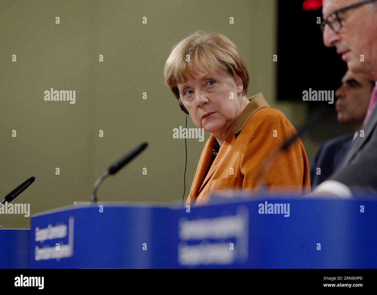 German Chancellor Angela Merkel (L) looks up during a press conference with European Commission President Jean-Claude Juncker (R) and the UN s High Commissioner for Refugees Antonio Guterres (not seen) at the end of the special EU summit with Western Balkan nations situated along the migrant routes into Europe in Brussels, Belgium, on Oct. 26, 2015. The European Union (EU) and Balkan countries are seeking further cooperation on tackling migrant crisis at a mini summit held here on Sunday. Zhou Lei) BELGIUM-EU SPECIAL SUMMIT-REFUGEE-WESTERN BALKAN ?? PUBLICATIONxNOTxINxCHN   German Chancellor A Stock Photo