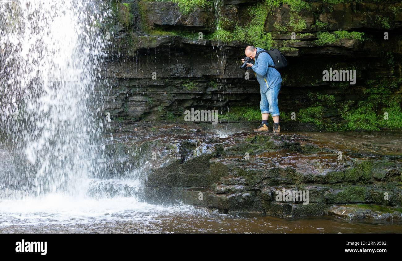 Photographer photographs waterfalls Stock Photo
