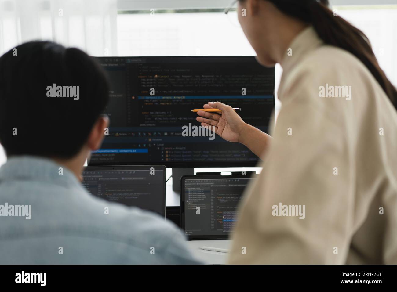 Two developer programmer discussing to checking code on monitor about programming to developing web. Stock Photo