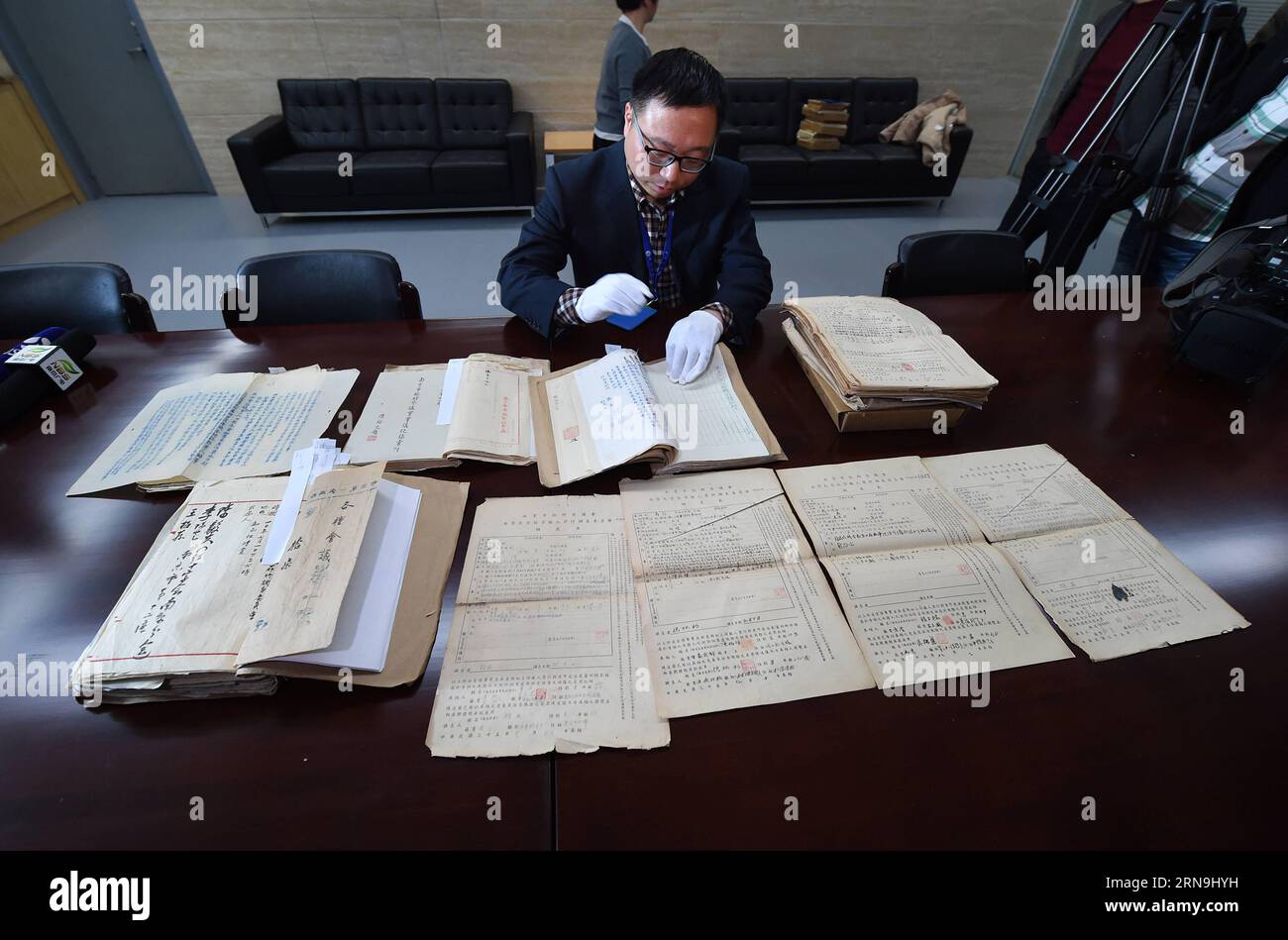 China präsentiert Forschungsergebnisse zum Massaker von Nanking (151208) -- NANJING, Dec. 8, 2015 -- A staff member of the Nanjing Municipal Archives shows files of Nanjing Massacre in Nanjing, capital of east China s Jiangsu Province, on Dec. 8, 2015. China has published files from the war crimes investigation into the Nanjing Massacre ahead of the national memorial day for the atrocity. The 15 files are just a small selection of the 2,784 which the Nanjing Provisional Municipal Council compiled between July and November 1946 and which have been listed in the Memory of the World Register by U Stock Photo