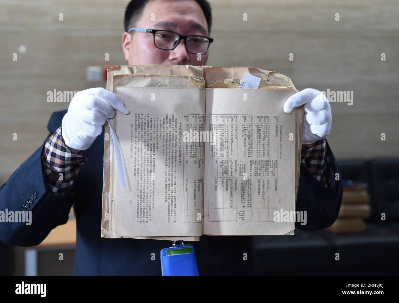 China präsentiert Forschungsergebnisse zum Massaker von Nanking (151208) -- NANJING, Dec. 8, 2015 -- A staff member of the Nanjing Municipal Archives shows files of Nanjing Massacre in Nanjing, capital of east China s Jiangsu Province, on Dec. 8, 2015. China has published files from the war crimes investigation into the Nanjing Massacre ahead of the national memorial day for the atrocity. The 15 files are just a small selection of the 2,784 which the Nanjing Provisional Municipal Council compiled between July and November 1946 and which have been listed in the Memory of the World Register by U Stock Photo