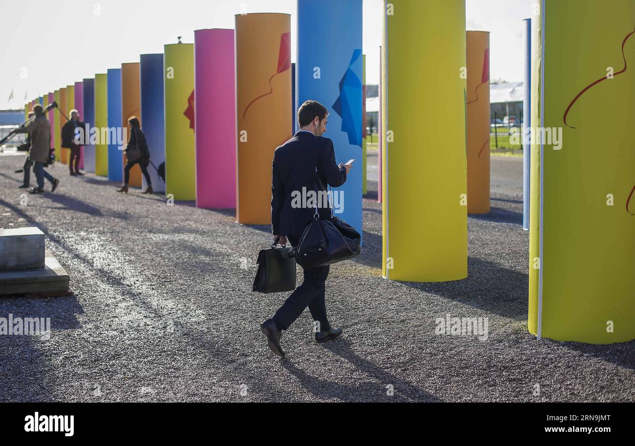 (151209) -- PARIS, Dec. 9, 2015 -- Participants walk at the venue of Paris Climate Change Conference at Le Bourget on the northern suburbs of Paris, France, Dec. 9, 2015. French Foreign Minister and President of Paris Climate Conference Laurent Fabius presented a new clean version of text for a global climate agreement on Wednesday as a basis for further negotiations among countries in the next 48 hours. The main outstanding issues that remain to be resolved include post-2020 climate finance, ambition of action and how to reflect the principle of common but differentiated responsibility in all Stock Photo