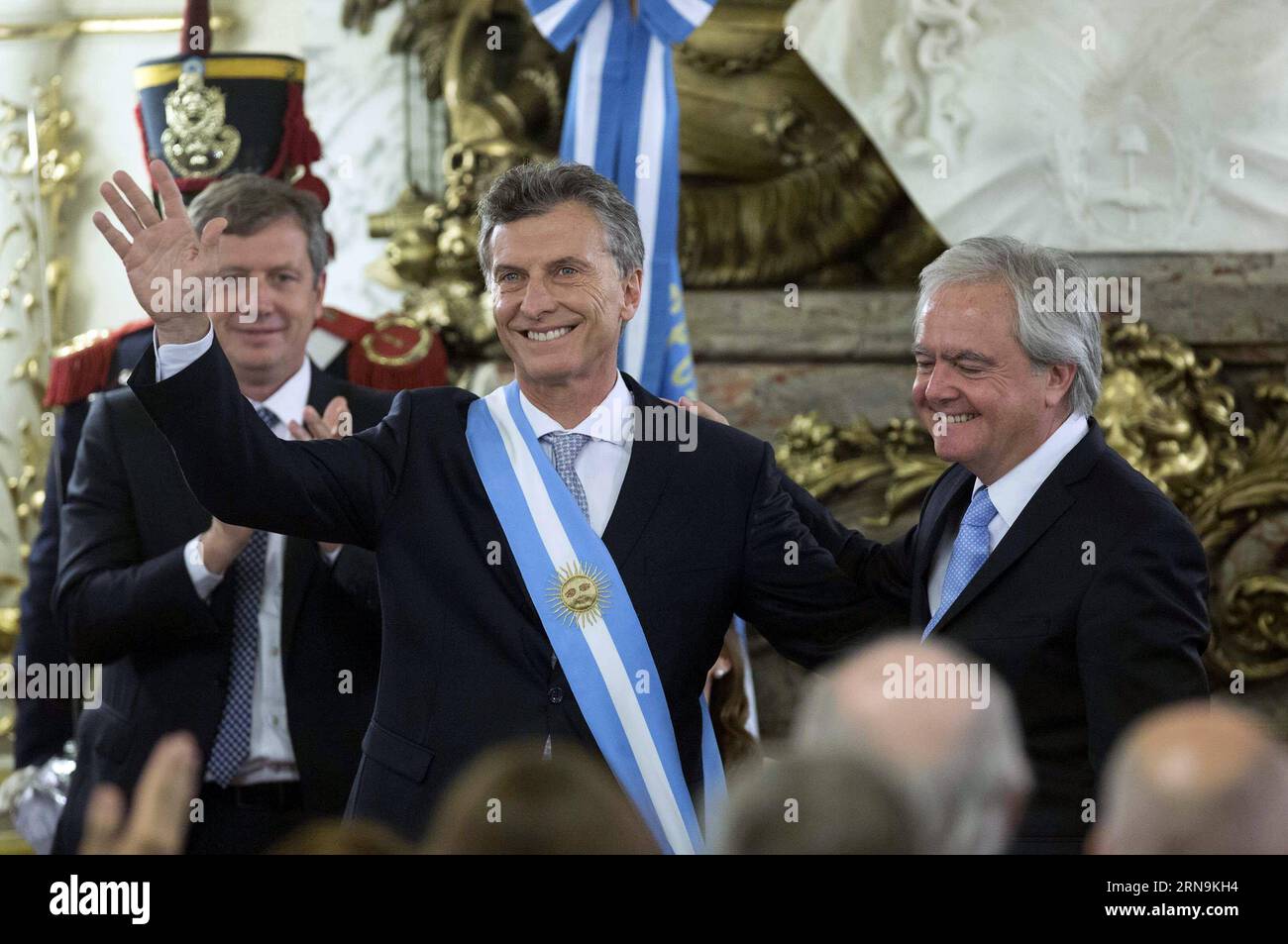 (151210) -- BUENOS AIRES, Dec. 10, 2015 -- Argentina s new President Mauricio Macri (C) waves after receiving the presidential sash from the provisional President of the Argentine Senate Federico Pinedo (R) at White Room of Casa Rosada (Pink House), in Buenos Aires city, capital of Argentina, on Dec. 10, 2015. Mauricio Macri on Thursday inaugurated as new Argentine President, succeeding Cristina Fernandez.Martin Zabala) (fnc) (ah) ARGENTINA-BUENOS AIRES-POLITICS-INAUGURATION e MARTINxZABALA PUBLICATIONxNOTxINxCHN   151210 Buenos Aires DEC 10 2015 Argentina S New President Mauricio Macri C Wave Stock Photo